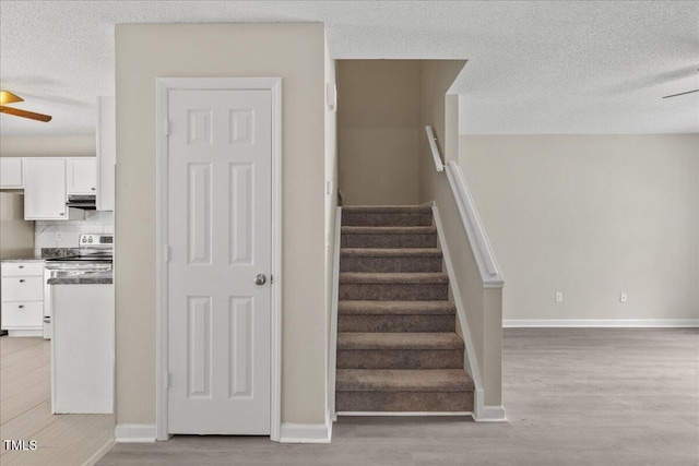 2228 Walnut Ridge Ct, Raleigh, NC 27610 - stairs featuring a ceiling fan, wood finished floors, a textured ceiling, and baseboards