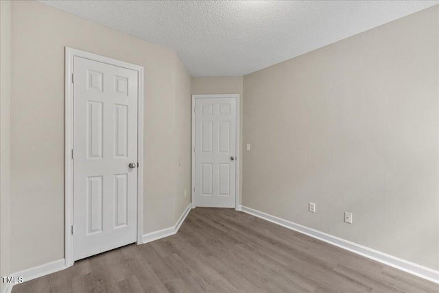 2228 Walnut Ridge Ct, Raleigh, NC 27610 - unfurnished bedroom with wood finished floors, a textured ceiling, and baseboards