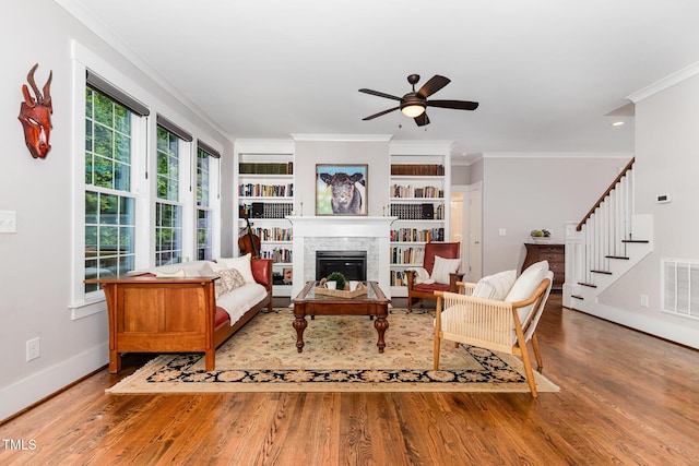 105 Everam Ct, Chapel Hill, NC 27516 - living area with a tiled fireplace, baseboards, ornamental molding, a ceiling fan, and light wood-type flooring