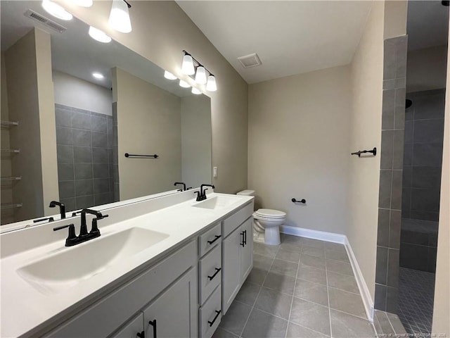 220 Gallery Dr Unit 201, Spring Lake, NC 28390 - bathroom with double vanity, tile patterned floors, baseboards, a walk in shower, and toilet