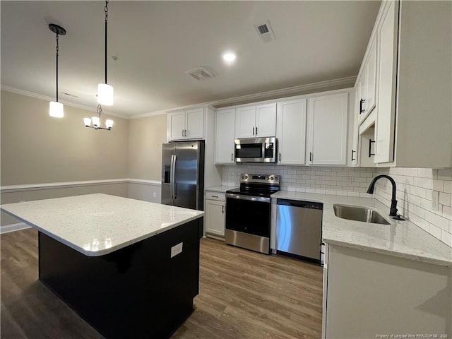 220 Gallery Dr Unit 201, Spring Lake, NC 28390 - kitchen featuring stainless steel appliances, ornamental molding, a center island, backsplash, and light stone counters