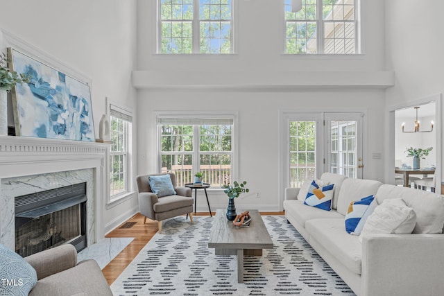 2575 Primrose Ln, Creedmoor, NC 27522 - living area featuring healthy amount of natural light, a towering ceiling, wood finished floors, and a high end fireplace