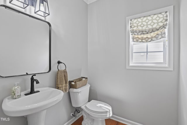 107 Trackimire Ln, Apex, NC 27539 - half bath with a sink, toilet, wood finished floors, and baseboards