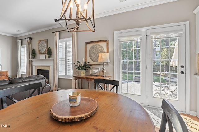 107 Trackimire Ln, Apex, NC 27539 - dining area featuring a chandelier, a fireplace, crown molding, and baseboards