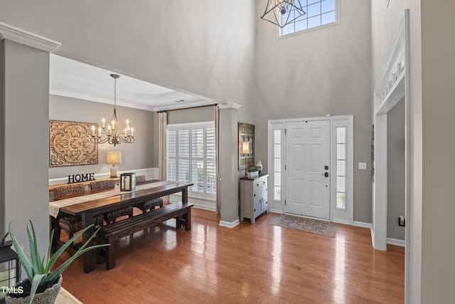 107 Trackimire Ln, Apex, NC 27539 - foyer entrance featuring a chandelier, plenty of natural light, light wood-style flooring, baseboards, and a high ceiling