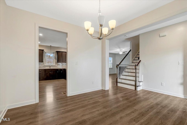 131 Hawick Ct, Zebulon, NC 27597 - unfurnished dining area with a chandelier, dark wood-style floors, stairway, and healthy amount of natural light