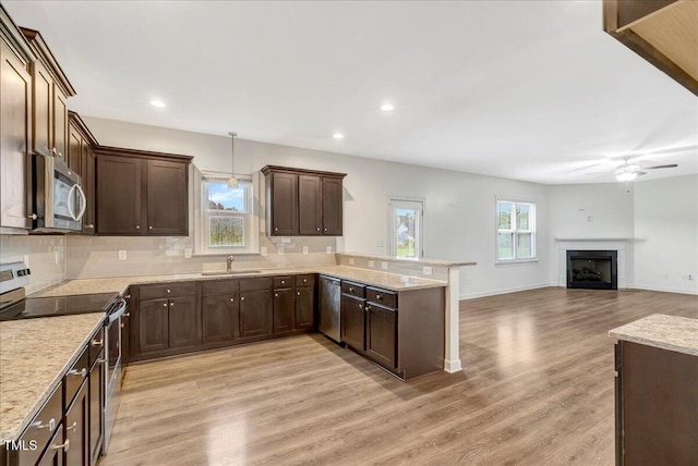 131 Hawick Ct, Zebulon, NC 27597 - kitchen featuring appliances with stainless steel finishes, a peninsula, decorative backsplash, a ceiling fan, and dark brown cabinetry