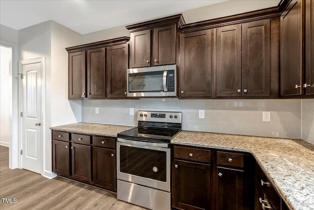 131 Hawick Ct, Zebulon, NC 27597 - kitchen with appliances with stainless steel finishes, light wood-style floors, dark brown cabinets, backsplash, and light stone countertops