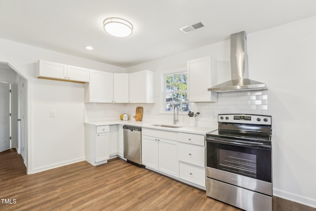 1246 NC-27, Benson, NC 27504 - kitchen with appliances with stainless steel finishes, wall chimney range hood, a sink, white cabinets, and recessed lighting