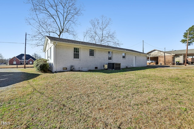 1246 NC-27, Benson, NC 27504 - rear view of house featuring central AC unit, a lawn, crawl space, and brick siding