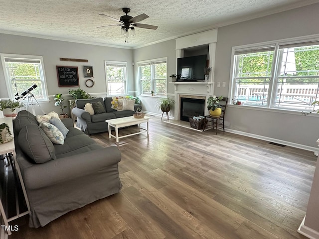 1003 Burnt Hickory Ct, Apex, NC 27502 - living area featuring a fireplace with flush hearth, crown molding, a ceiling fan, wood finished floors, and baseboards