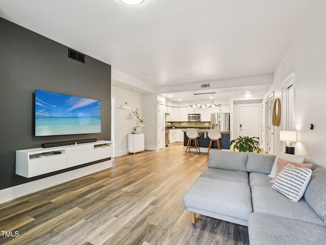 222 Glenwood Ave Unit 213, Raleigh, NC 27603 - living room featuring light wood-style floors and a chandelier