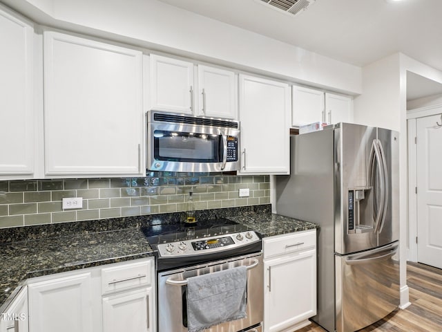 222 Glenwood Ave Unit 213, Raleigh, NC 27603 - kitchen with stainless steel appliances, white cabinets, decorative backsplash, and dark stone countertops
