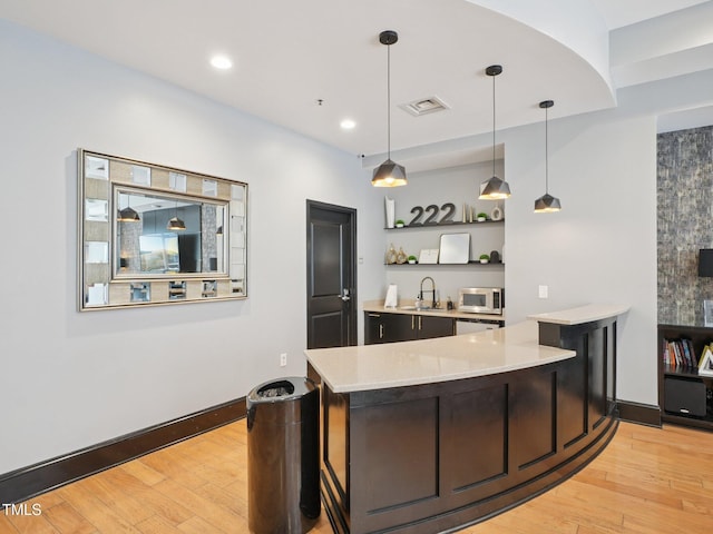 222 Glenwood Ave Unit 213, Raleigh, NC 27603 - bar with white microwave, light wood-type flooring, hanging light fixtures, and recessed lighting