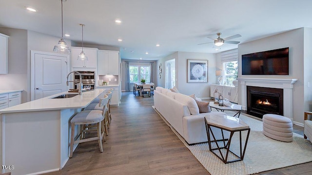 1124 Sun Springs Rd, Wake Forest, NC 27587 - living area with recessed lighting, wood finished floors, a ceiling fan, a lit fireplace, and baseboards