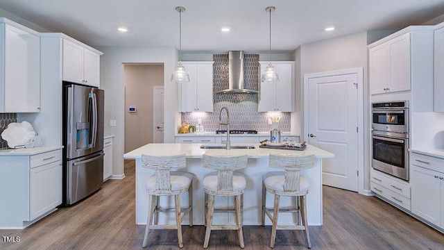 1124 Sun Springs Rd, Wake Forest, NC 27587 - kitchen with appliances with stainless steel finishes, wall chimney exhaust hood, backsplash, a kitchen island with sink, and dark wood-type flooring