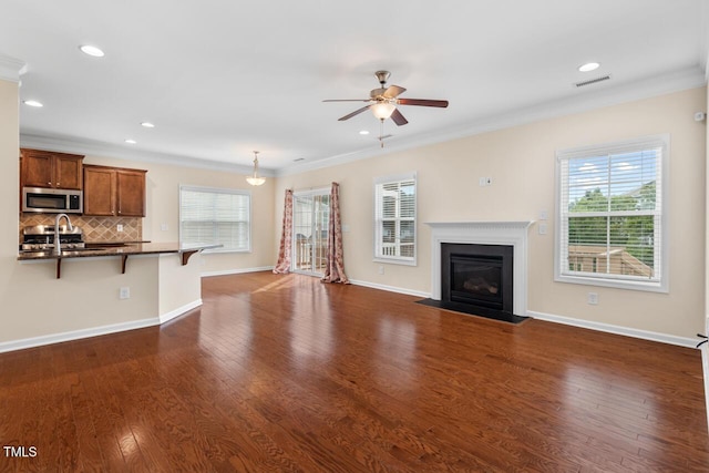 210 Strolling Way, Durham, NC 27707 - unfurnished living room with a ceiling fan, plenty of natural light, a fireplace with flush hearth, ornamental molding, and recessed lighting