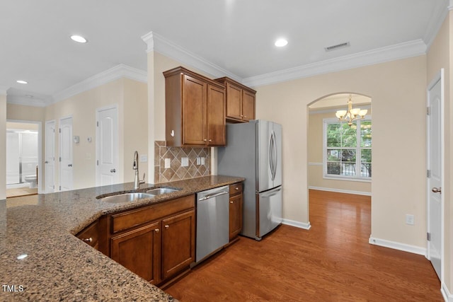210 Strolling Way, Durham, NC 27707 - kitchen with a sink, stainless steel appliances, brown cabinets, wood finished floors, and stone counters