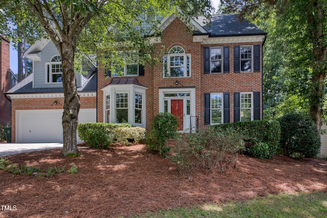 405 Widdington Ln, Cary, NC 27519 - colonial house featuring brick siding, a garage, driveway, and roof with shingles