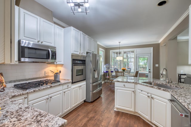 405 Widdington Ln, Cary, NC 27519 - kitchen with stainless steel appliances, crown molding, dark wood-style flooring, white cabinets, and backsplash