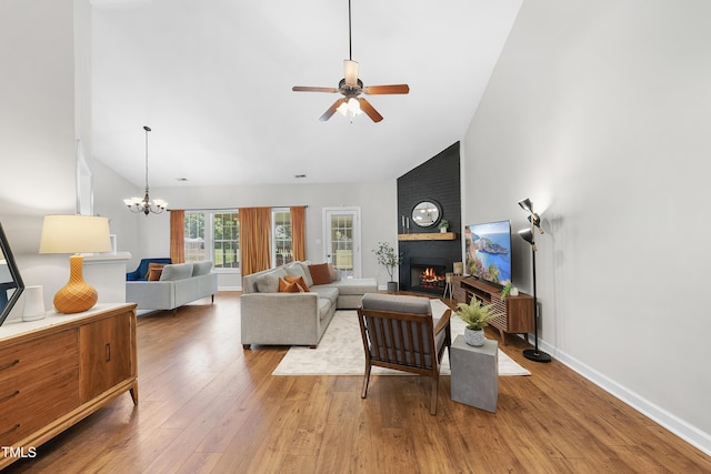 3705 Highland Creek Dr, Apex, NC 27539 - living room with a large fireplace, wood finished floors, a ceiling fan, high vaulted ceiling, and a chandelier