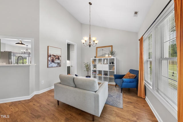 3705 Highland Creek Dr, Apex, NC 27539 - living room with a chandelier, wood finished floors, high vaulted ceiling, and baseboards