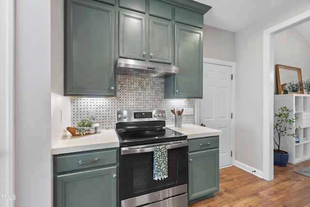 3705 Highland Creek Dr, Apex, NC 27539 - kitchen with green cabinetry, electric stove, under cabinet range hood, light wood-style floors, and light countertops