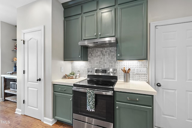 3705 Highland Creek Dr, Apex, NC 27539 - kitchen featuring green cabinets, stainless steel electric range, under cabinet range hood, decorative backsplash, and light wood-style flooring