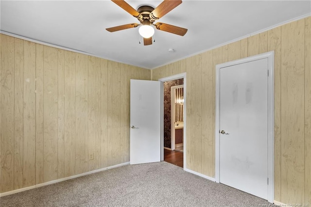 741 Ashboro St, Fayetteville, NC 28311 - unfurnished bedroom featuring carpet, wood walls, a ceiling fan, baseboards, and crown molding