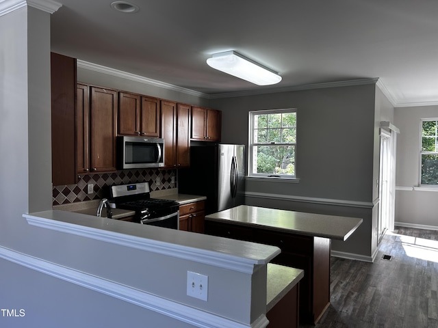 1527 Haywards Heath Ln, Apex, NC 27502 - kitchen featuring stainless steel appliances, plenty of natural light, backsplash, dark wood finished floors, and ornamental molding