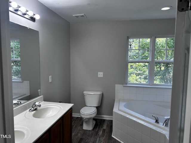 1527 Haywards Heath Ln, Apex, NC 27502 - full bathroom with toilet, a bath, double vanity, wood finished floors, and baseboards