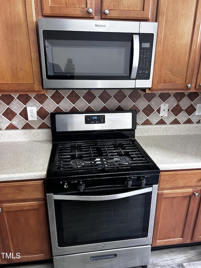1527 Haywards Heath Ln, Apex, NC 27502 - kitchen featuring appliances with stainless steel finishes, decorative backsplash, and light countertops