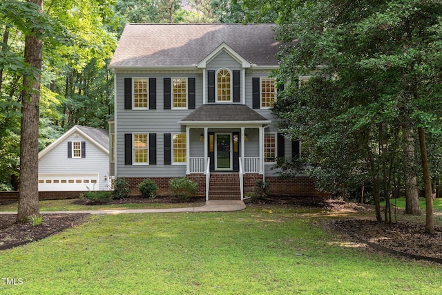 7604 Copper Creek Ct, Wake Forest, NC 27587 - colonial home with covered porch, a front lawn, roof with shingles, and an outbuilding