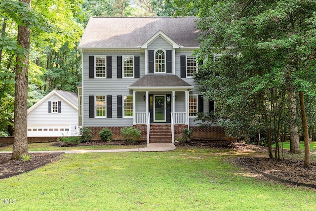 7604 Copper Creek Ct, Wake Forest, NC 27587 - colonial inspired home featuring covered porch, a front yard, a detached garage, and a shingled roof