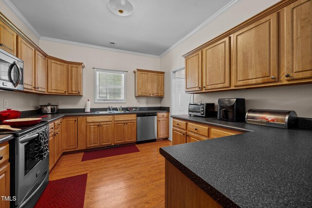 106 Oak Rd, Butner, NC 27509 - kitchen with stainless steel appliances, ornamental molding, light wood finished floors, a sink, and dark countertops