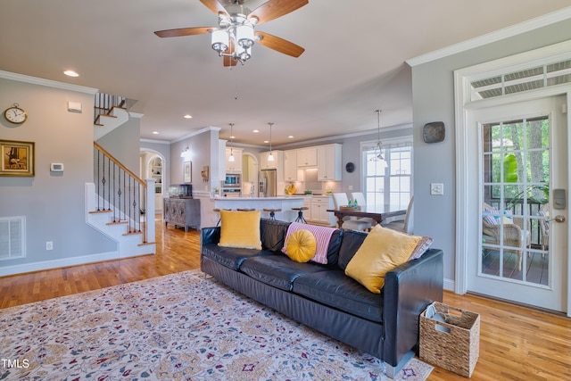 1161 Golden Star Way, Wake Forest, NC 27587 - living room featuring stairs, light wood finished floors, ornamental molding, ceiling fan, and baseboards