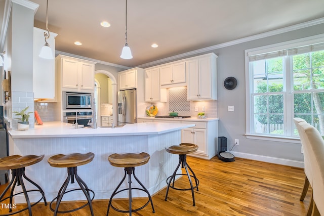 1161 Golden Star Way, Wake Forest, NC 27587 - kitchen with appliances with stainless steel finishes, a peninsula, ornamental molding, baseboards, and backsplash