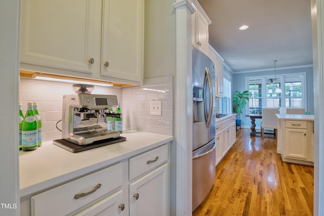 1161 Golden Star Way, Wake Forest, NC 27587 - kitchen with stainless steel fridge, light wood finished floors, backsplash, crown molding, and light countertops