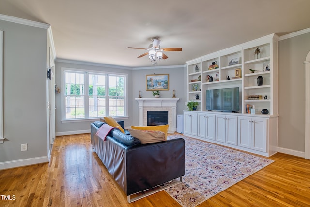 1161 Golden Star Way, Wake Forest, NC 27587 - living area with a fireplace, ceiling fan, light wood finished floors, baseboards, and crown molding