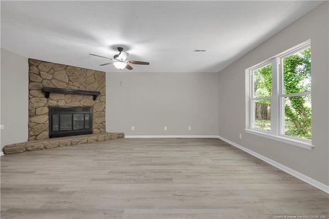 6263 Stoney Point Loop, Fayetteville, NC 28306 - unfurnished living room with baseboards, ceiling fan, light wood-style floors, and a stone fireplace