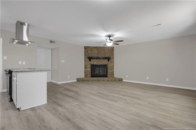 6263 Stoney Point Loop, Fayetteville, NC 28306 - unfurnished living room featuring a ceiling fan, light wood-style flooring, baseboards, and a fireplace