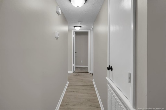 6263 Stoney Point Loop, Fayetteville, NC 28306 - corridor featuring baseboards, light wood-style floors, and a textured ceiling
