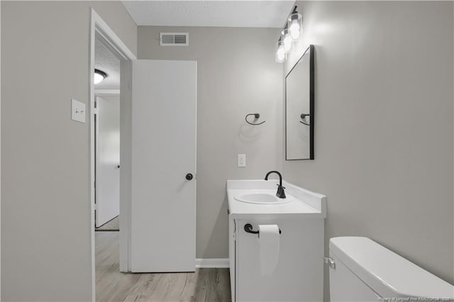 6263 Stoney Point Loop, Fayetteville, NC 28306 - half bathroom featuring vanity, toilet, wood finished floors, and baseboards