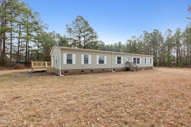 752 Dundee Cir, Raeford, NC 28376 - manufactured / mobile home featuring crawl space, a wooden deck, view of scattered trees, and a front lawn