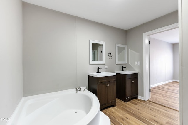752 Dundee Cir, Raeford, NC 28376 - bathroom with wood finished floors, two vanities, and a bath