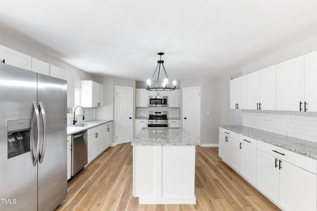 752 Dundee Cir, Raeford, NC 28376 - kitchen featuring appliances with stainless steel finishes, decorative backsplash, a chandelier, a kitchen island, and white cabinetry