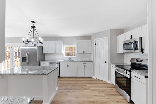 752 Dundee Cir, Raeford, NC 28376 - kitchen with stainless steel appliances, a sink, backsplash, and a chandelier