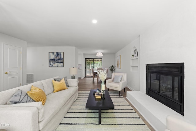 216 Burkwood Ln, Raleigh, NC 27609 - living area featuring baseboards, wood finished floors, a glass covered fireplace, and built in features