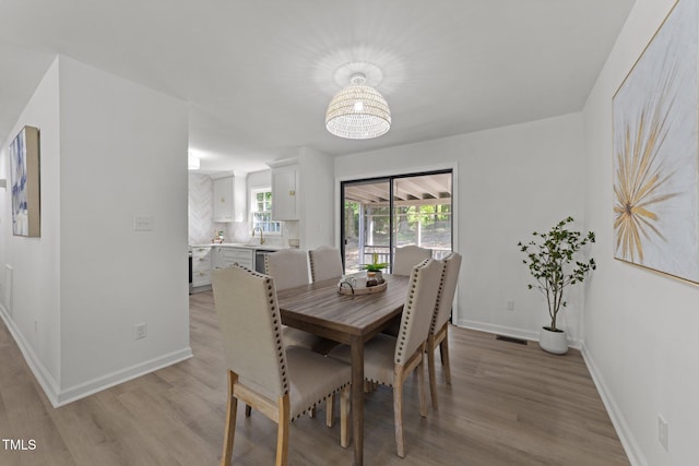 216 Burkwood Ln, Raleigh, NC 27609 - dining area featuring light wood-type flooring, baseboards, and a chandelier