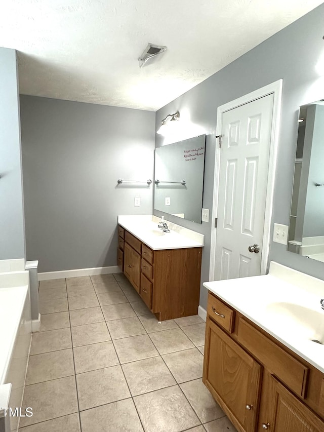 75 Mountainside Ln, Sanford, NC 27332 - bathroom with two vanities, tile patterned floors, a bathtub, and baseboards